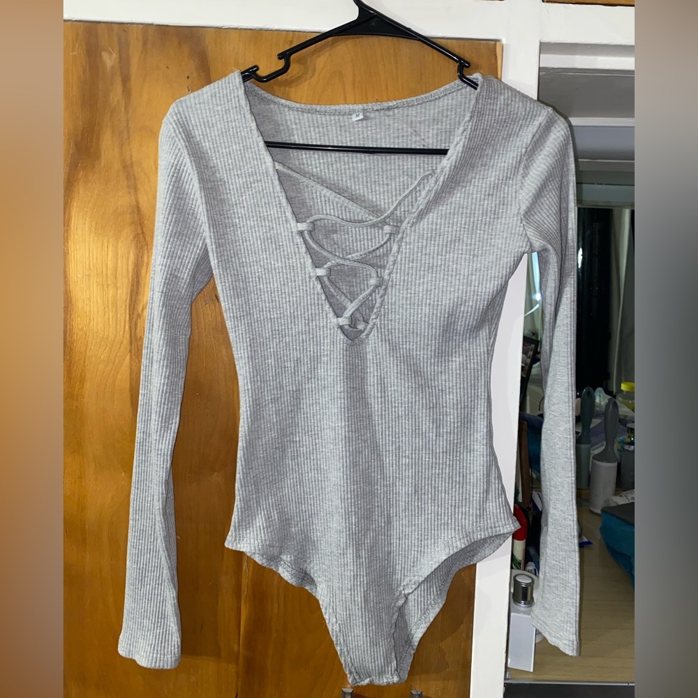 Grey body suit, very low v-neck